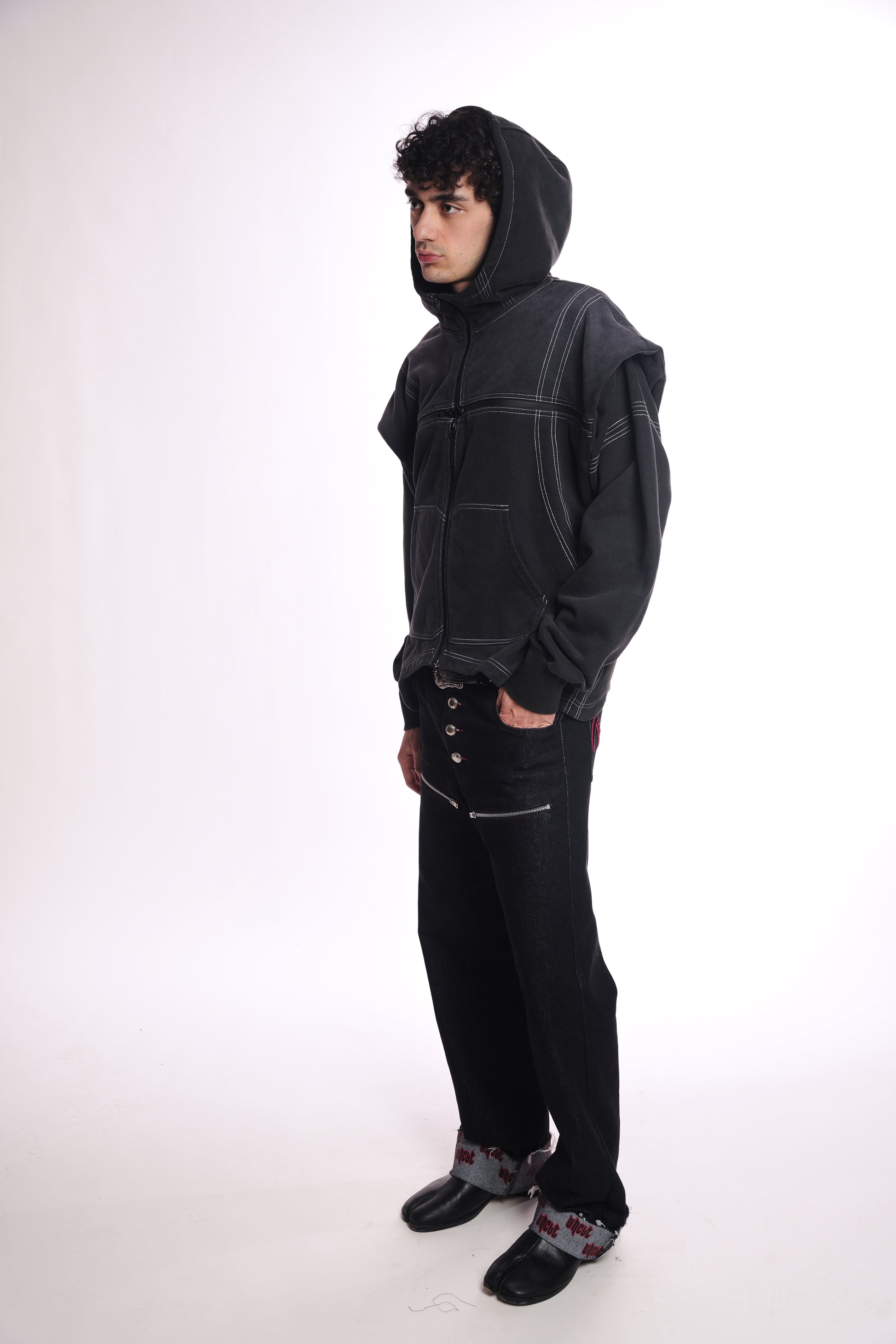 Person wearing a black hoodie OGP ZIP UP and pants on a white background