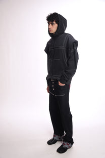 Person wearing a black hoodie OGP ZIP UP and pants on a white background