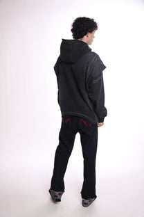 Person wearing a black hoodie OGP zip up  and pants on a white background