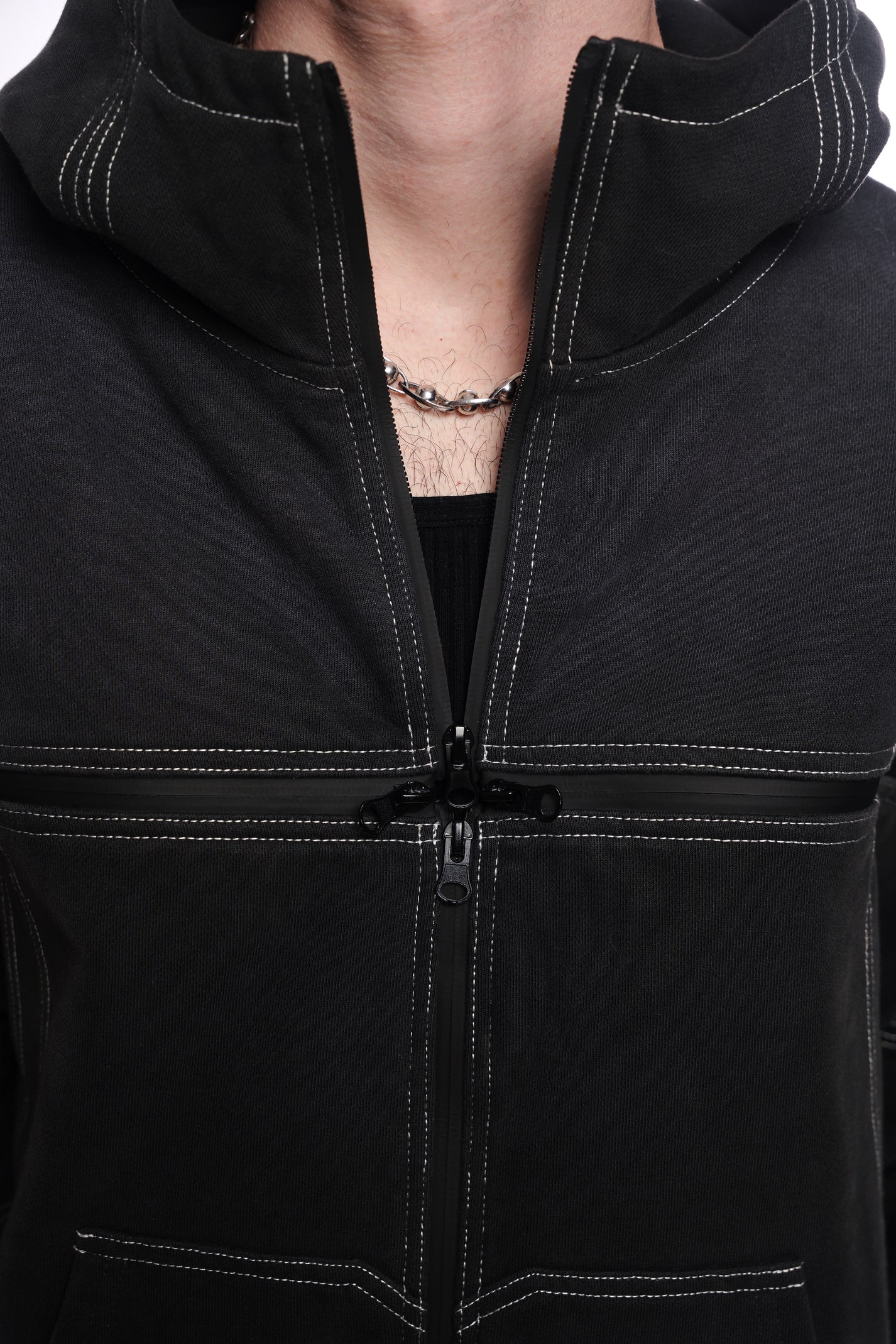 Close-up of a black jacket with a  quad zipper, worn by a person.