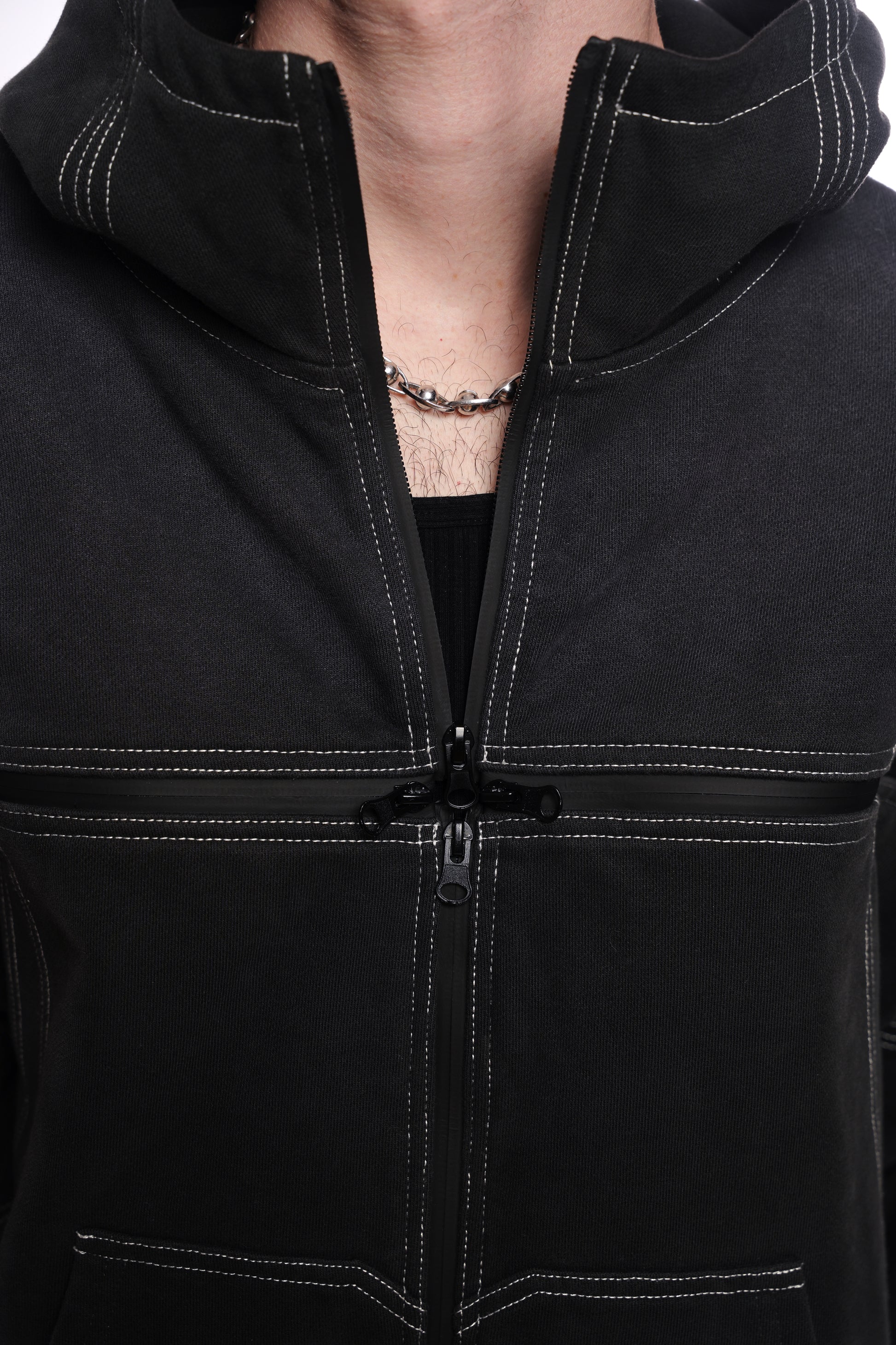 Close-up of a black jacket with a  quad zipper, worn by a person.