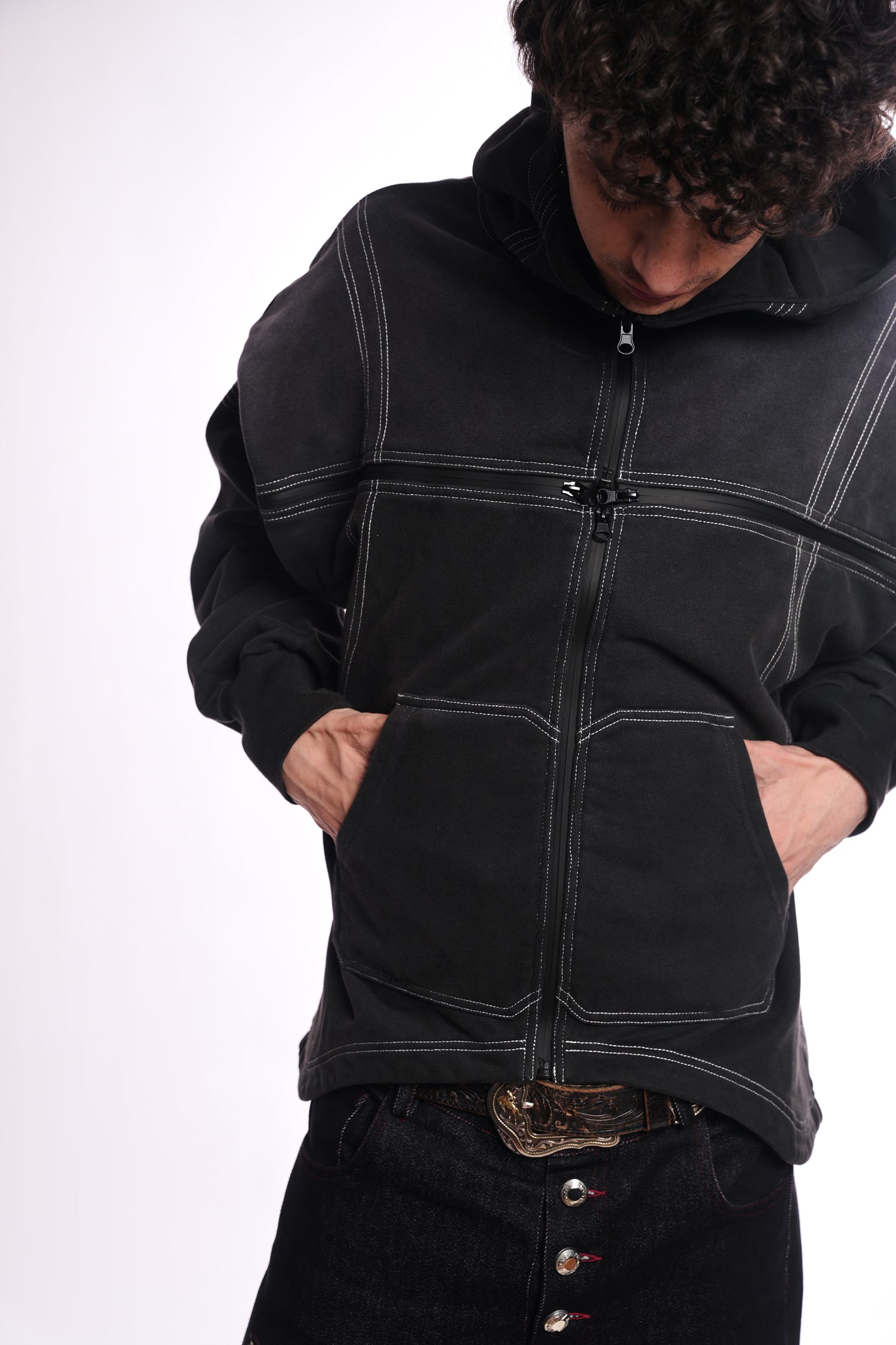 Person wearing a black jacket with quad zipper accents on a white background