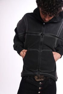 Person wearing a black jacket with quad zipper accents on a white background