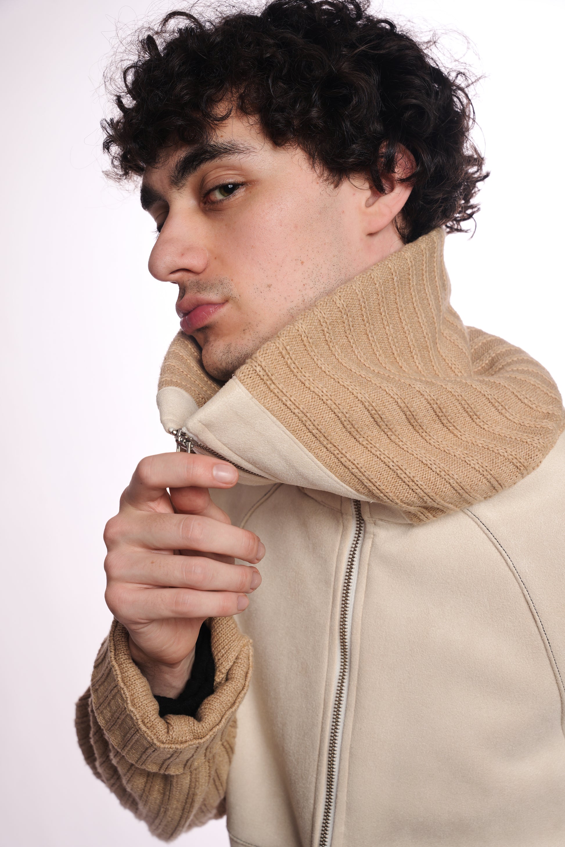 Man wearing a beige jacket with a knitted collar on a white background