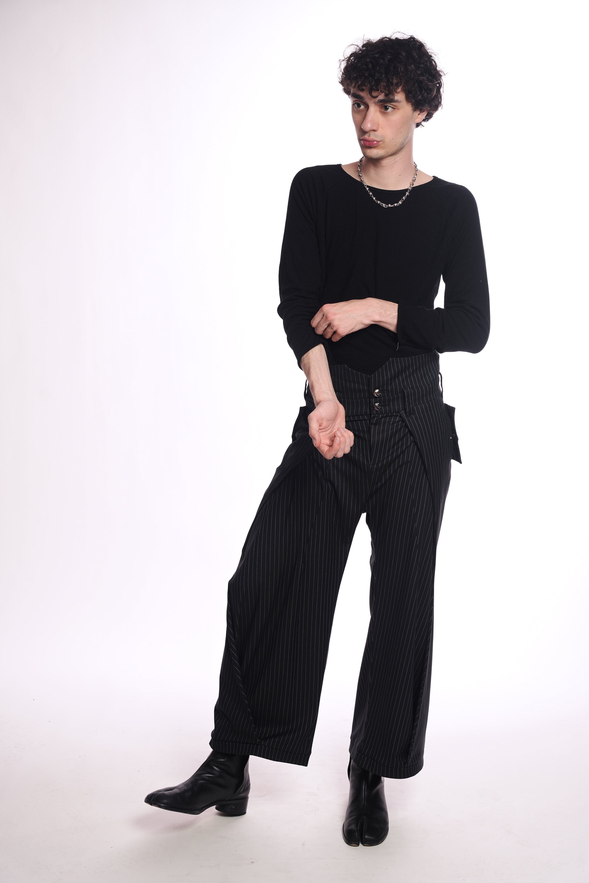 Person wearing a black outfit with wide-leg pants on a white background