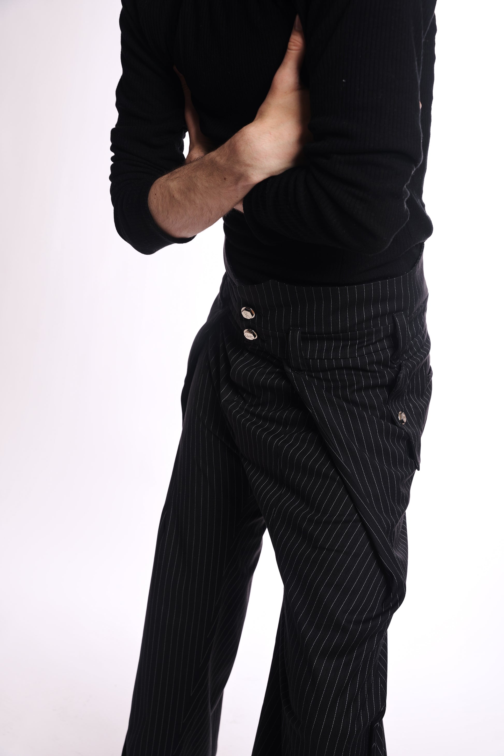 Person wearing a black sweater and pinstripe pants on a white background