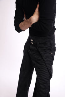 Person wearing a black sweater and pinstripe pants on a white background