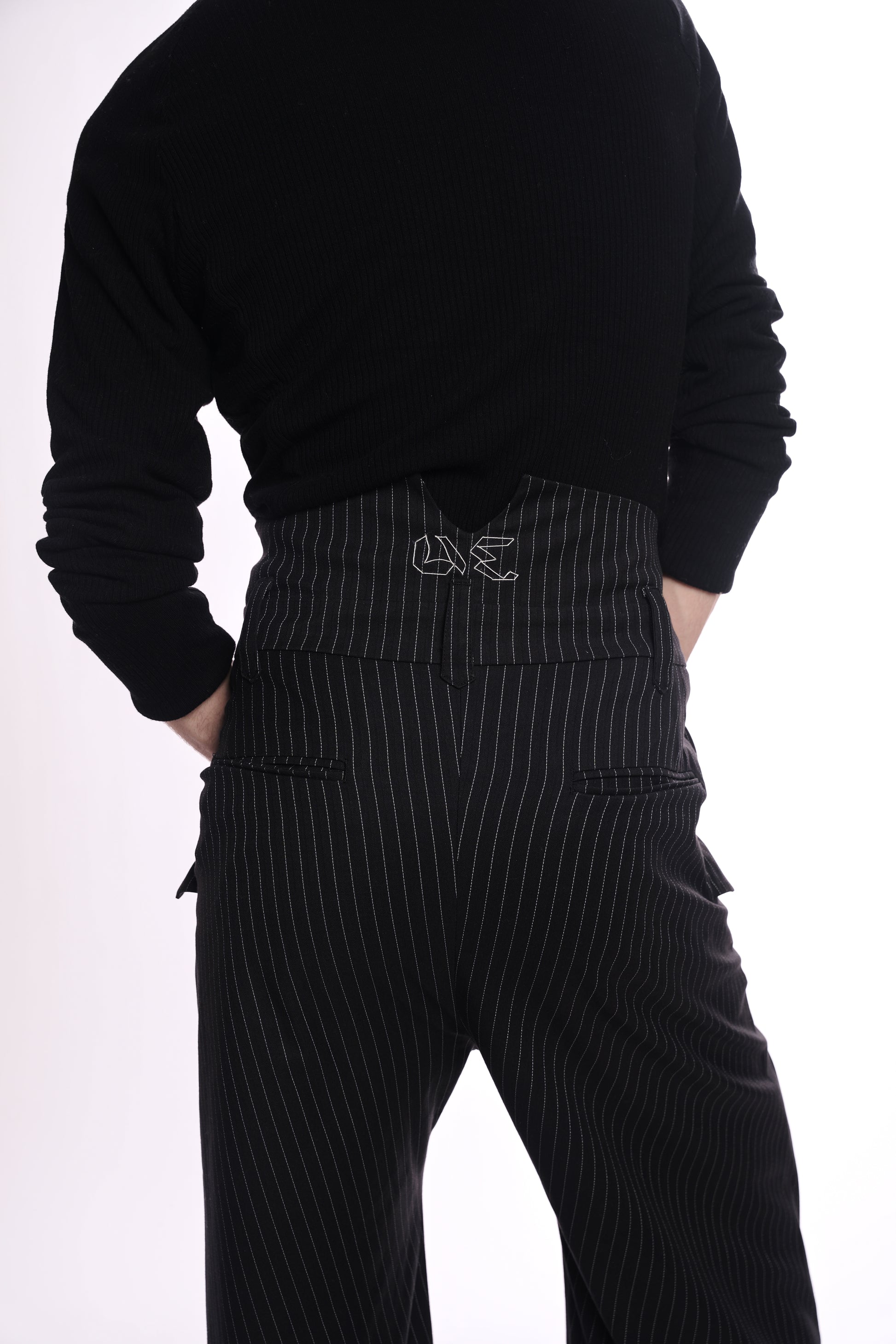 Person wearing a black sweater and pinstripe pants on a white background